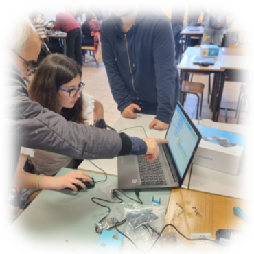 Elevi programând pe laptop o placă electronică