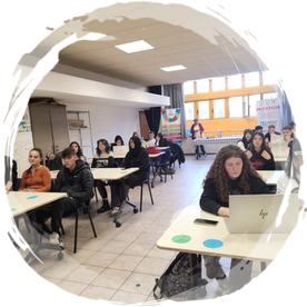 Elevi lucrând la mese într-o sală de curs mare